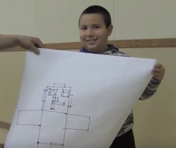 A Keota elementary school 3rd grader shares his robot drawing with his classmates.